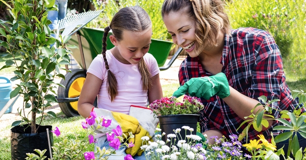 Mum and daughter in garden looking at plants