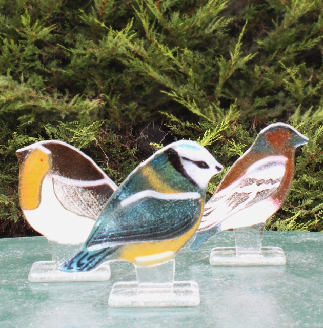 three glass birds on a table