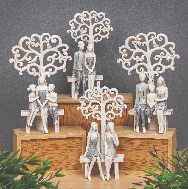 figurines of people sitting on a bench with a tree behind them