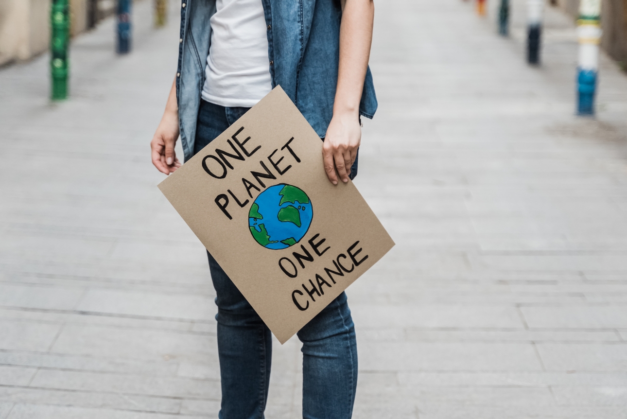 man holding a sign one planet one chance