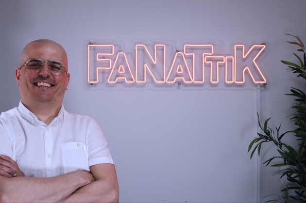 Luiz Ferreira stands in front of Fanattik neon sign