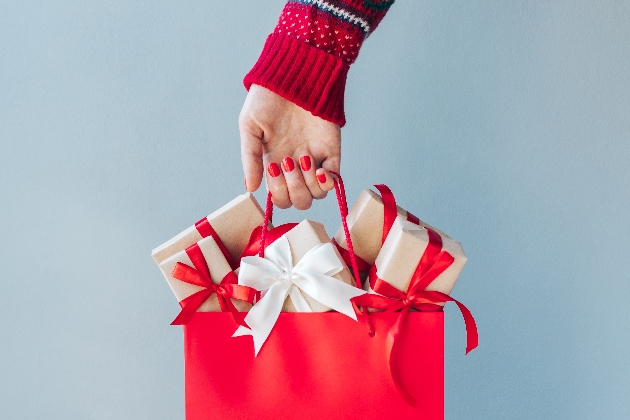 red paper bag holding Christmas presents