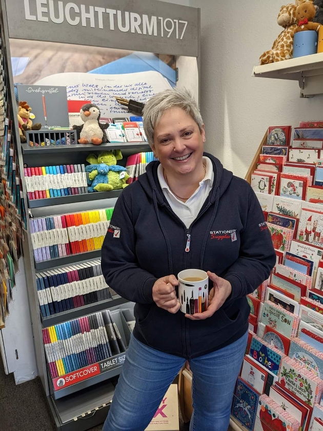 lady with cropped hair standing in front of greeting cards display