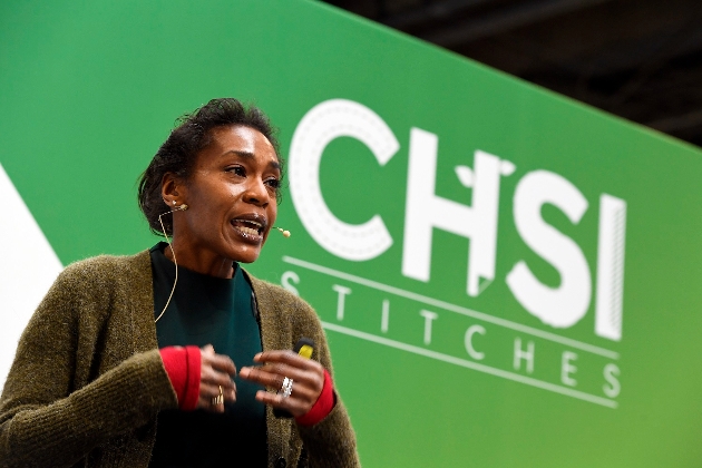 Lady in green top talks in front of CHSI stiches banner