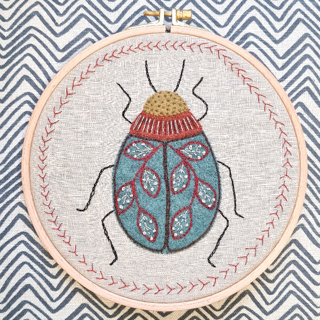 bug on a cross stitch frame