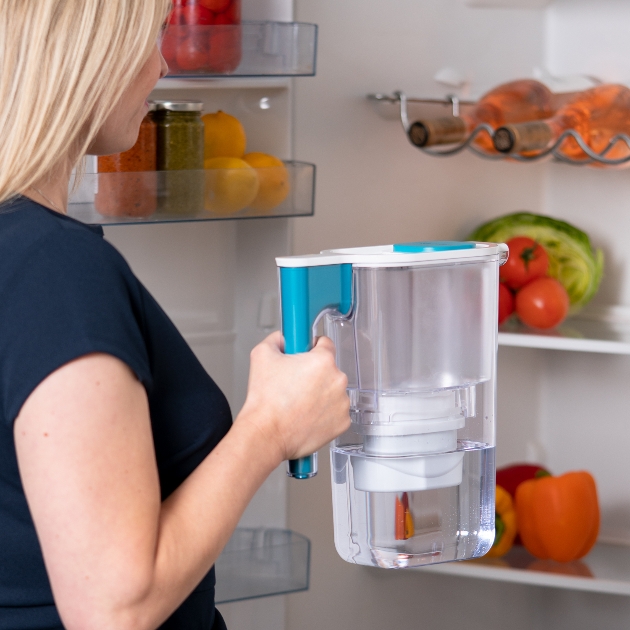 woman putting water filter in fridge