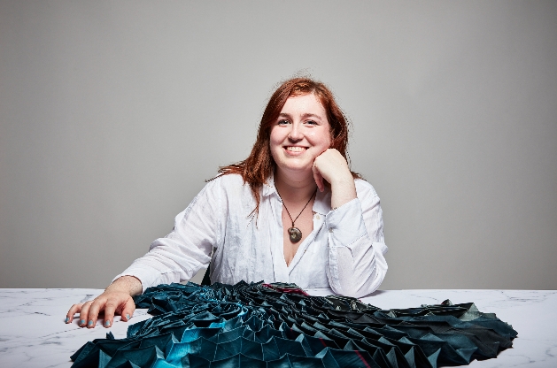 woman in white shirt at table with blue material in front of her