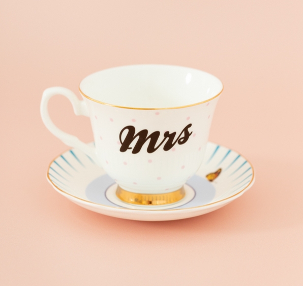 white tea cup and saucer with mrs on it and blue detail