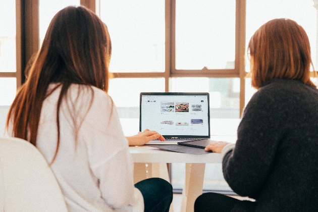 two people sat at a lap top 