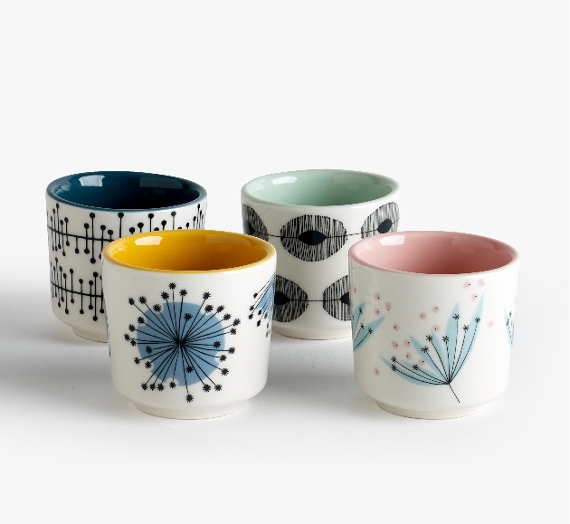 four white china cups with prints on and four different coloured insides 