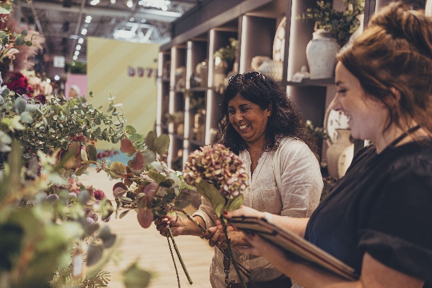 two women looking at faux flowers