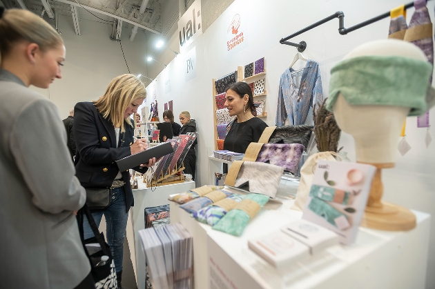 blonde lady signing order book at show stand