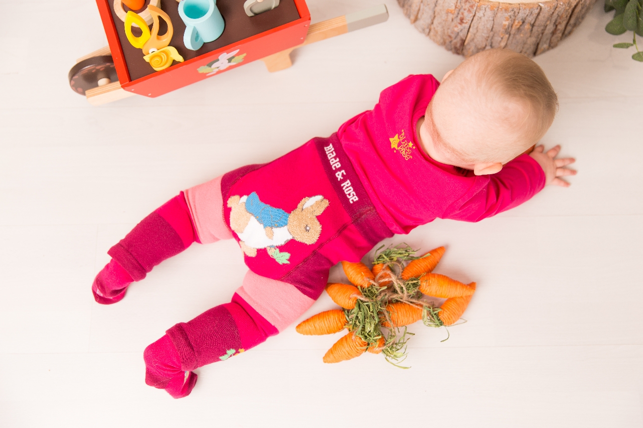 baby in knitted pink legging with peter rabbit image