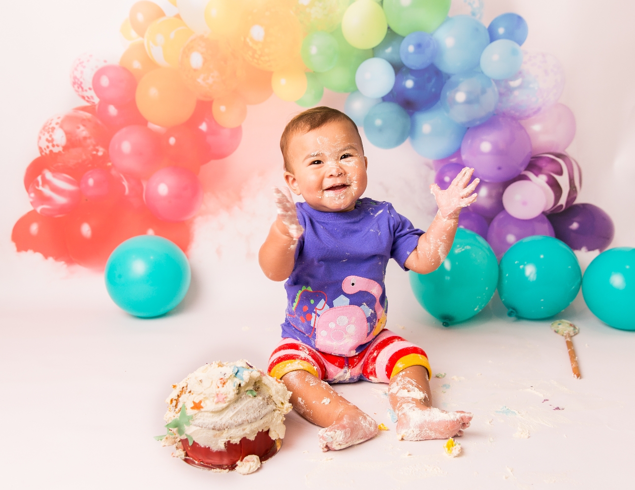 baby in colourful clothes at cake smash shoot