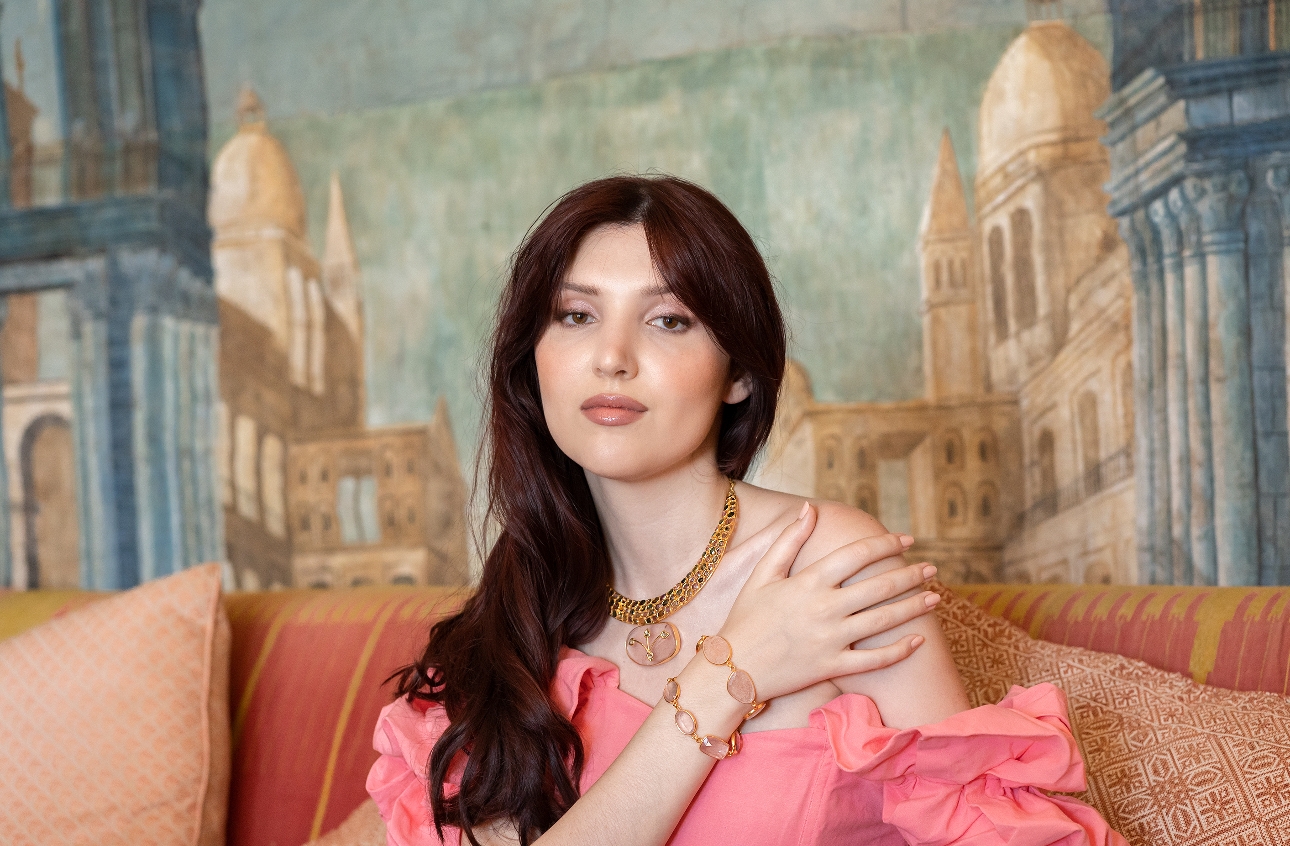 model in pink top with gold and pink necklace and bracelets