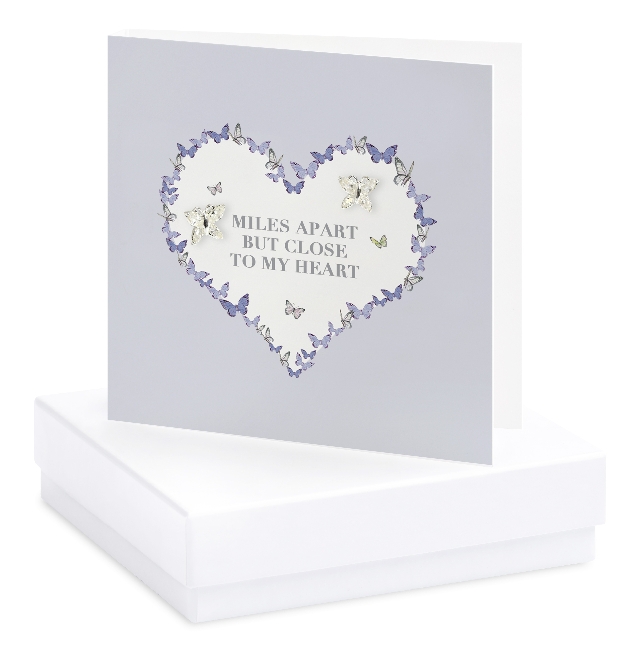 card on white box with purple flowers and silver earring attached to it