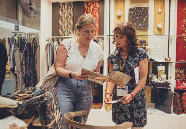 Two ladies reading catalogue at trade show stand