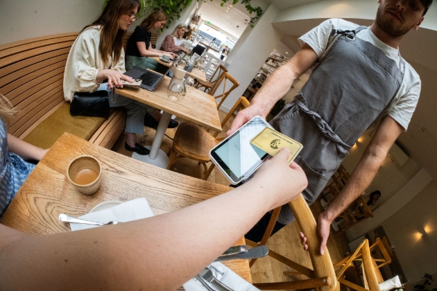 person making card payment in cafe
